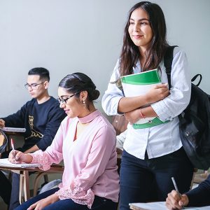 latin woman student stand up in classroom with other students
